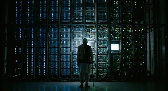 An elderly figure standing in silhouette before a massive wall of glowing server racks